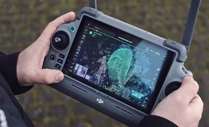 Surveyor using DJI Matrice 4 controller with live aerial surveying data display